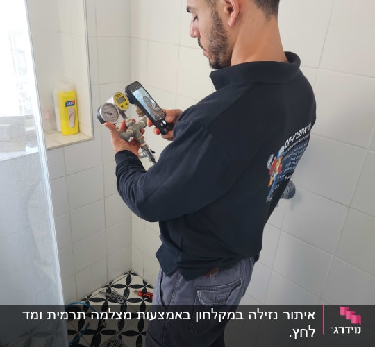 אדם מצלם מד לחץ עם טלפון נייד